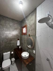 een badkamer met een toilet, een wastafel en een spiegel bij Chalé Brisa do Pontal in Fortim +34 foto's