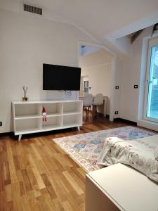 a white living room with a flat screen tv on the wall at Appartamento Mara in Domodossola