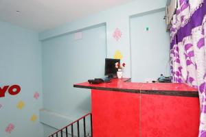 a room with a red counter with a computer on it at Star Hospitality in kolkata