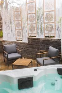 wanna z hydromasażem, 2 krzesła i stół w obiekcie Spa Residence Seibold w mieście Waldkirchen