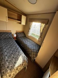 a small room with two beds and a window at 52 Sherringham Way in Patrington