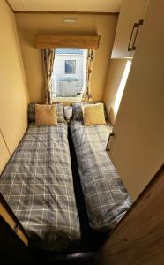 two beds in a small room with a window at 52 Sherringham Way in Patrington