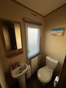a small bathroom with a toilet and a sink at 52 Sherringham Way in Patrington