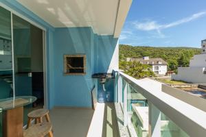 een balkon met een blauwe muur en een tafel en stoelen bij Village Eco Park in Bombinhas