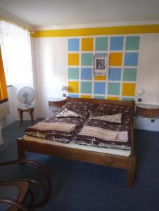 - une chambre avec un lit et un mur coloré dans l'établissement Pension U Galerie, à Český Krumlov