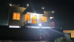 a house at night with the lights on at Nordik Hotel in Nkumba