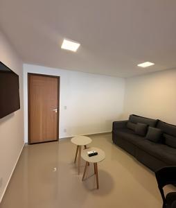 een woonkamer met een bank en een tafel bij RM hospedagem unidade Amapá 2 in Cabo Frio
