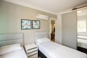 een slaapkamer met twee bedden en een raam bij Village Eco Park in Bombinhas +89 foto's