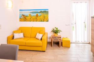 een woonkamer met een gele bank en een tafel bij MillyHolidays - Apartment Sunflower - Center - Nearby Beach - Private Garden - Spa Pool in Bardolino