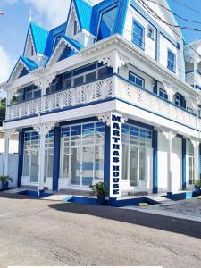 a white and blue building with a blue roof at Martha's House Lexus in Soufrière