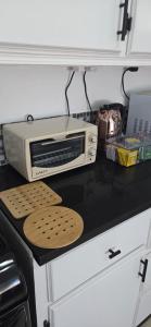 a toaster oven sitting on top of a kitchen counter at Martha's House Lexus in Soufrière +1 photo
