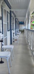 a row of white chairs and tables on a building at Martha's House Lexus in Soufrière