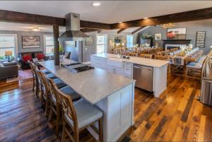 a large kitchen with a large island with bar chairs at Whispering Prairie Lodge in Salina