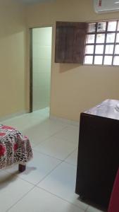 a room with a bed and a table in it at Aconchego em Peroba in Maragogi +1 photo