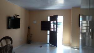 a living room with a door and a tv and a room at Aconchego em Peroba in Maragogi