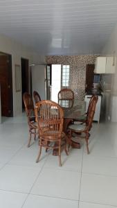 a dining room with a table and wooden chairs at Aconchego em Peroba in Maragogi