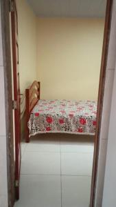 a bedroom with a bed with a floweredspread on it at Aconchego em Peroba in Maragogi