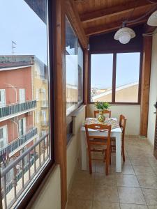 a balcony with a table and chairs and a window at Affitto breve Puccio A Chiazza Realmonte in Realmonte