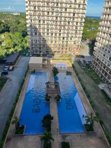 an aerial view of two swimming pools in front of a large building at seakyung village in Suba