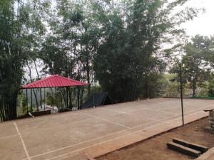 a tennis court with a canopy and a tennis court at Mur Farm House in Sonāpur
