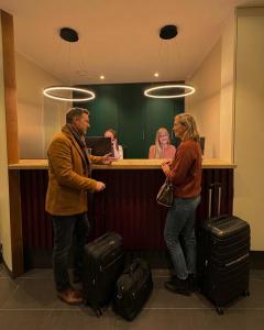 een man en een vrouw aan een balie met bagage bij Das Mühlentor Hotel in Bad Kreuznach