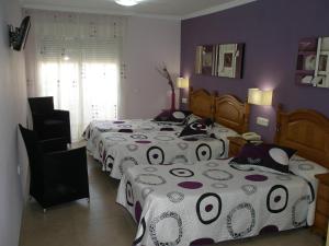 a bedroom with two beds and a room with purple walls at Hotel Noguera El Albir in Albir