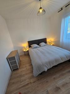 a bedroom with a bed and two night stands and two lamps at Gîte Familial in Nabringhen