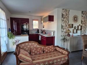 a living room with a couch and a kitchen at Charmante maison in Lacs