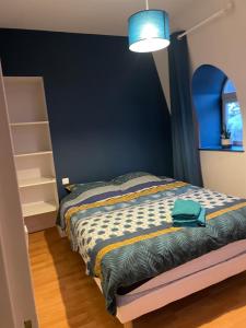 a bedroom with a bed and a blue wall at le ROYAT in Royat