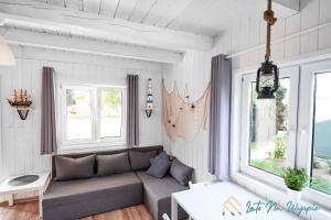 a living room with a couch and two windows at LATO NA WYSPIE in Gdańsk
