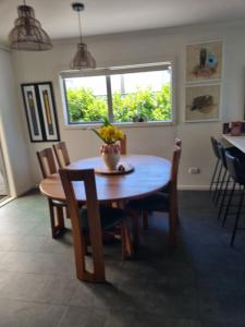 a dining room with a table and chairs and a window at Norfolk House in Gisborne +2 photos