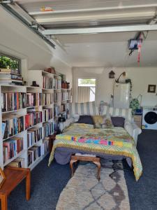 a bedroom with a bed and bookshelves at Norfolk House in Gisborne
