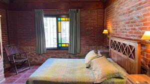 a bedroom with a bed and a brick wall at Encantos del Bosque in Colón +53 photos