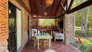 a patio with a table with chairs and a ceiling at Encantos del Bosque in Colón