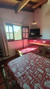 a room with a bed and a table and windows at Zahra Depto in Villa Gesell