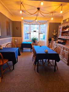 a dining room with blue tables and chairs at Trillberry Guesthouse in Weymouth