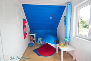 a childs room with a blue wall at LATO NA WYSPIE in Gdańsk