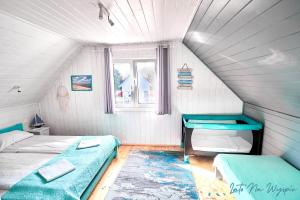 a attic room with two beds and a window at LATO NA WYSPIE in Gdańsk
