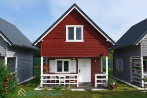 a red house with a white door and two gray houses at LATO NA WYSPIE in Gdańsk