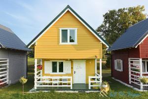 a yellow house with a white door in a yard at LATO NA WYSPIE in Gdańsk +41 photos