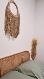 un cesto di vimini appeso a una parete sopra un letto di Világos Kert Garden Suites -Balatonvilágos a Balatonvilágos
