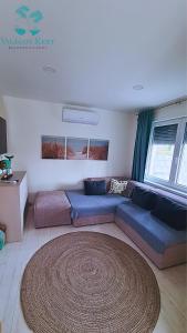 un soggiorno con divano blu e un grande tappeto di Világos Kert Garden Suites -Balatonvilágos a Balatonvilágos