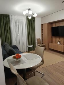 een woonkamer met een tafel en een bank bij Zen aeroport confort in Sînnicoară