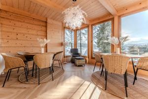 a dining room with a table and chairs and a chandelier at Czorna Chata u Chocyków & SPA in Czarna Góra