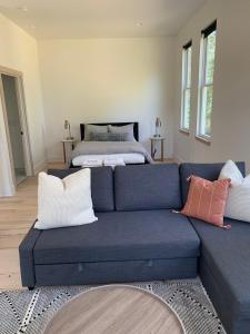 a living room with a blue couch and a bed at Sautee Nacoochee Studio near Helen in Sautee Nacoochee