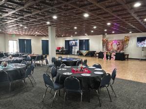 a banquet hall with black tables and chairs and a stage at Expedition Lodge Estes Park at Rocky Mtn National Park in Estes Park +55 photos