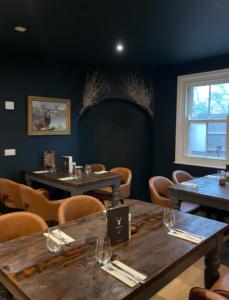 a dining room with wooden tables and chairs at The Stag in Salhouse