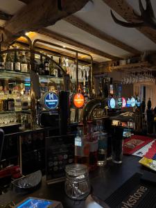 a bar with a counter and a bar with alcohol at The Stag in Salhouse