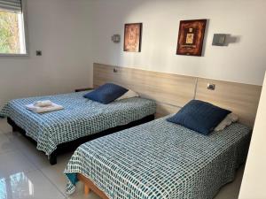 two beds in a room with blue pillows at Casa di a Murza vue citadelle Rdc in Calvi