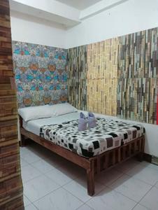a bedroom with a bed with two purple shoes on it at Constrell Pension House in Tagbilaran City +10 photos